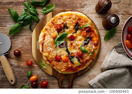 Pizza Margherita on a wooden background Pizza Margherita on a wooden background 106998465