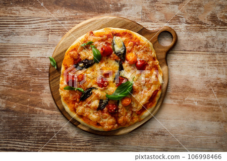 Pizza Margherita on a wooden background Pizza Margherita on a wooden background 106998466