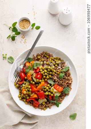 Buckwheat with roasted vegetables and green peas 106998477