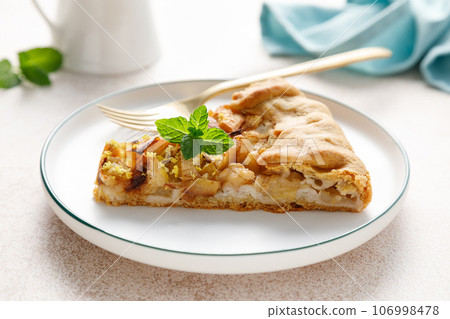Apple pie slice with cinnamon and lemon zest on a plate 106998478
