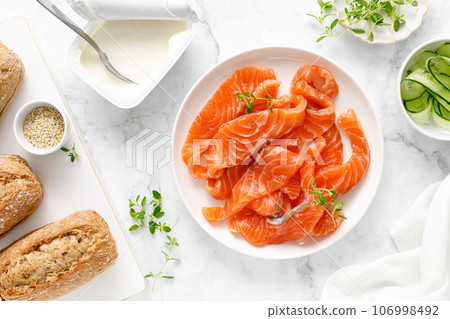 Salted salmon sliced on plate on a white background, top down view 106998492