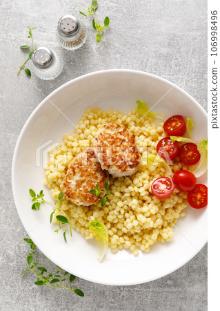 Couscous with chicken patties, cutlets and tomatoes, top down view Couscous with chicken patties, cutlets and tomatoes, top down view 106998496