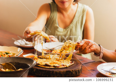 Woman hands taking slices of pizza with friends. 106999231