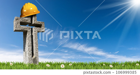 Orange Safety Helmet or Hard Hat on a Stone Cross 106999385