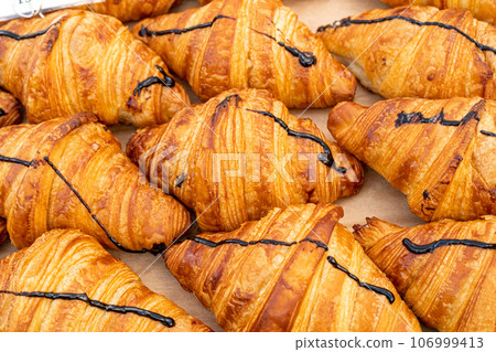 Many Croissant at Street Market, Fresh Puff Pastry Pies, Sweet Kipferls, Buttery Chocolate-Nutty Viennoiseries 106999413
