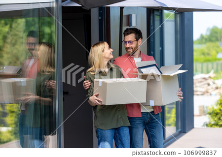 Couple preparing to relocation and carrying containers with clothes Couple preparing to relocation and carrying containers with clothes 106999837