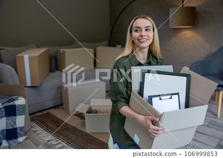 Smiling blonde woman with a box in hands Smiling blonde woman with a box in hands 106999853