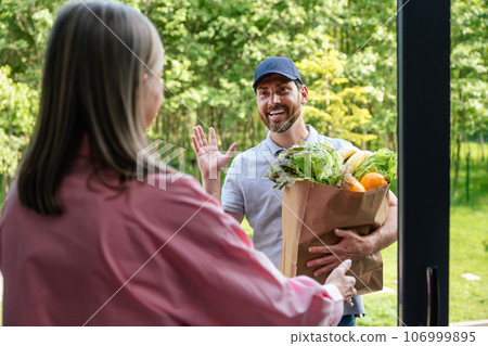 Man courier delivering paper bags with takeaway food. Man courier delivering paper bags with takeaway food. 106999895