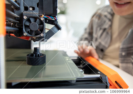 Man checking 3d printer, process of making things on 3d printer in laboratory. Man checking 3d printer, process of making things on 3d printer in laboratory. 106999964