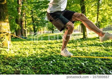 Close up picture of a man balancing on the rope 107000667