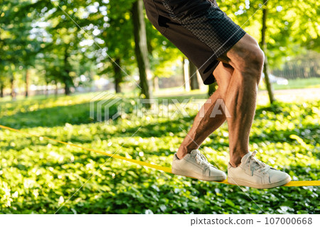 Close up picture of a man balancing on the rope 107000668