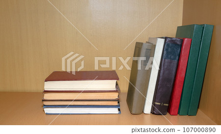 Old books lie and stand on a shelf in a wooden bookcase. Reading, education, classic literature 107000890