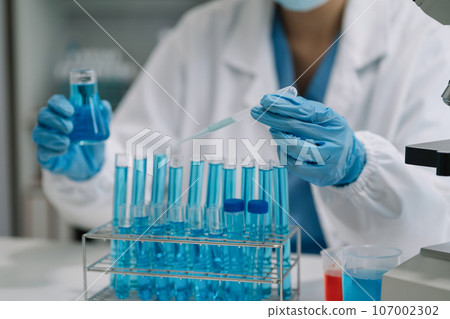 Scientist mixing chemical liquids in the chemistry lab. Researcher working in the chemical laboratory. Scientist mixing chemical liquids in the chemistry lab. Researcher working in the chemical laboratory. 107002302