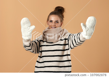 happy young woman in wool sweater and mittens happy young woman in wool sweater and mittens 107002878