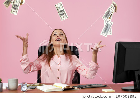 pretty businesswoman throwing money on pink background. 107002892