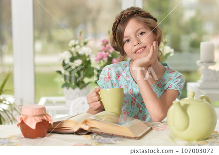 Close up portrait of young girl reading interesting big book Close up portrait of young girl reading interesting big book 107003072