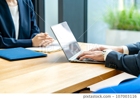 Business men and women, computers at hand 107003116