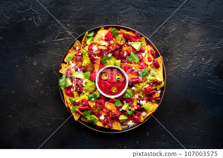 Loaded nachos. Mexican nacho chips with beef, overhead flat lay shot 107003575