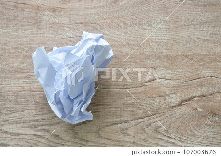 crumple white paper throw on wooden table 107003676