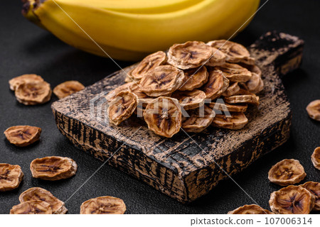 Round slices of sweet banana on a dark concrete background Round slices of sweet banana on a dark concrete background 107006314