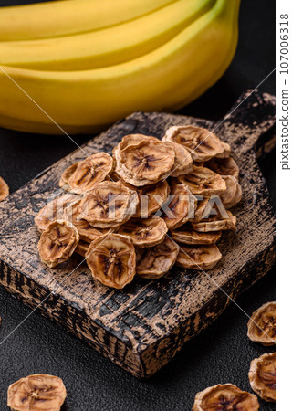 Round slices of sweet banana on a dark concrete background Round slices of sweet banana on a dark concrete background 107006318