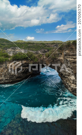 Majestic cliffs surround a serene turquoise bay at Broken Beach, Nusa Penida 107006370