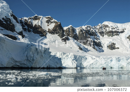 Tourists watching glaciers and mountains in Paradise bay,peninsula, Antartica.. 107006372