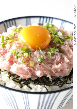 A bowl of shredded seaweed, egg yolk, and green onions is photographed against a white background. 107006599