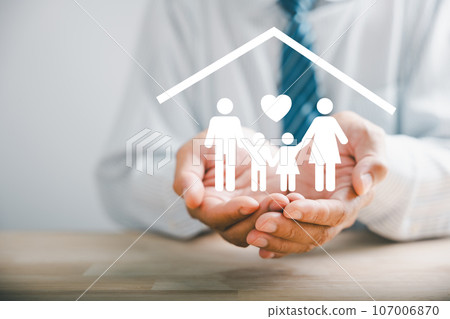 Fostering family well-being, Businessman protective gesture resonates with young family silhouette. Health and house insurance icons underscore safety and care, emphasizing family support. 107006870