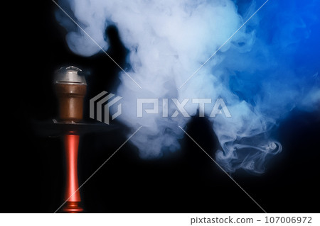 White blue smoke smoker cloud from hookah clay head pipe object on black background, close up 107006972
