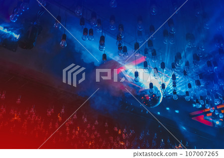 Nightclub atmosphere, ceiling, interior with neon, red and blue light in smoke with disco shiny ball 107007265