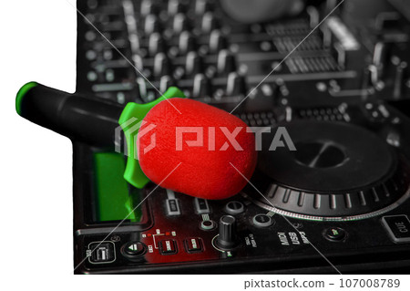 A professional microphone instrument singing karaoke lies on a DJ controller, close-up on white background A professional microphone instrument singing karaoke lies on a DJ controller, close-up on white background 107008789