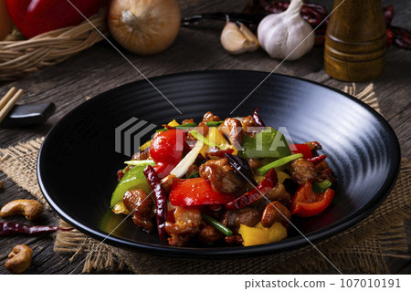 Stir fried crispy chicken with cashew nuts and sweet pepper in black plate.Thai food not spicy. Stir fried crispy chicken with cashew nuts and sweet pepper in black plate.Thai food not spicy. 107010191