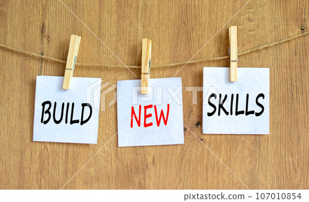 Build new skills symbol. Concept word Build new skills on beautiful white paper on wooden clothespin. Beautiful wooden table wooden background. Business, education build new skills concept. Copy space Build new skills symbol. Concept word Build new skills on beautiful white paper on wooden clothespin. Beautiful wooden table wooden background. Business, education build new skills concept. Copy space 107010854