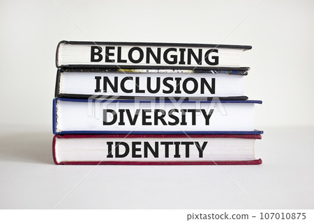 Belonging symbol. Books with words 'belonging, inclusion, diversity identity' on beautiful white table, white background. Business, belonging, diversity and inclusion concept. Copy space. 107010875