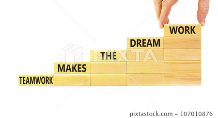 Teamwork makes dream work symbol. Concept words Teamwork makes the dream work on wooden blocks on beautiful white background. Businessman hand. Business Teamwork makes dream work concept. Copy space. Teamwork makes dream work symbol. Concept words Teamwork makes the dream work on wooden blocks on beautiful white background. Businessman hand. Business Teamwork makes dream work concept. Copy space. 107010876