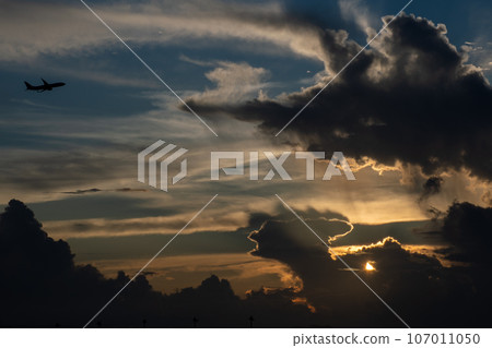 Airplane silhouette flying at sunset Airplane silhouette flying at sunset 107011050