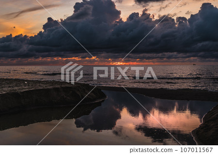 sunset on a sandy beach with dramatic cloudy sky in Golem, Durres, Albania 107011567