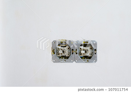 Double open electrical socket on a grungy gray wall. Double open electrical socket on a grungy gray wall. 107011754