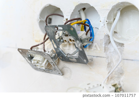 Open electrical socket on a grungy gray wall. Open electrical socket on a grungy gray wall. 107011757