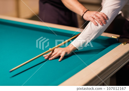 Billiard coach trainer instructor teaches player at billard table or snooker american billiards pool sport game 107012167