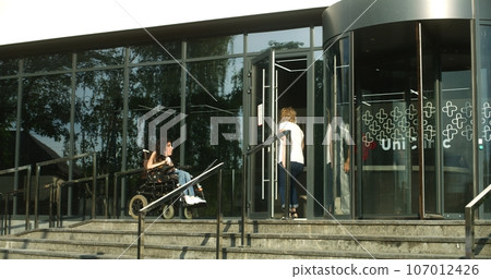 Woman with physical disability rides into clinic entrance 107012426