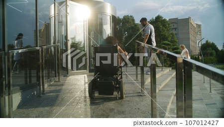 Woman with physical disability rides in hospital on wheelchair 107012427
