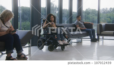 Woman with SMA disability waits for consultation with doctor 107012439