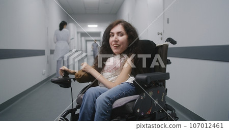 Woman with spinal muscular atrophy looks at camera 107012461