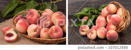 peaches in a wicker basket with leaves on wooden table 107012898