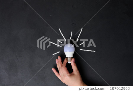 A woman's hand holds an electric lamp, the concept of searching for new ideas, startup A woman's hand holds an electric lamp, the concept of searching for new ideas, startup 107012963