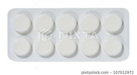 Round tablets in white plastic packaging, top view 107012972