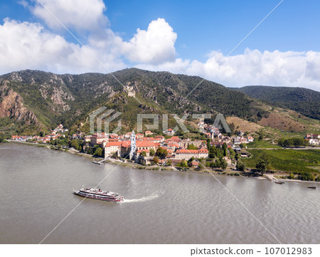 Panorama of Wachau valley (Unesco world heritage site) with ship on Danube river against Duernstein village in Lower Austria, Austria 107012983