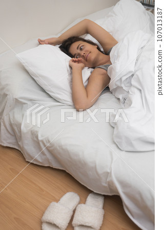 healthy woman sleeps on bed with light linen enjoying sleep near stylish home bedroom 107013187